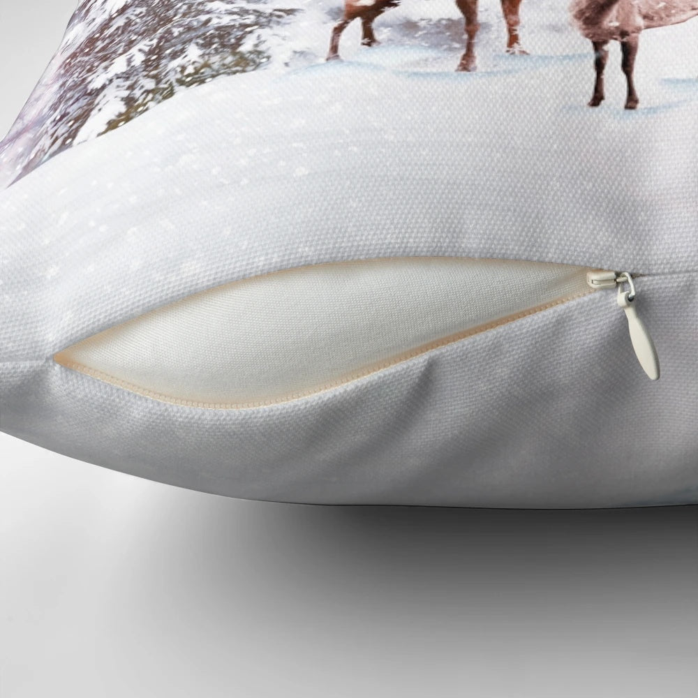 A cozy winter wonderland throw pillow with a deer stag design, surrounded by snowy trees.