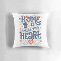 A decorative throw pillow with the inspirational quote "Home is where your heart is" in a handwritten typography design.