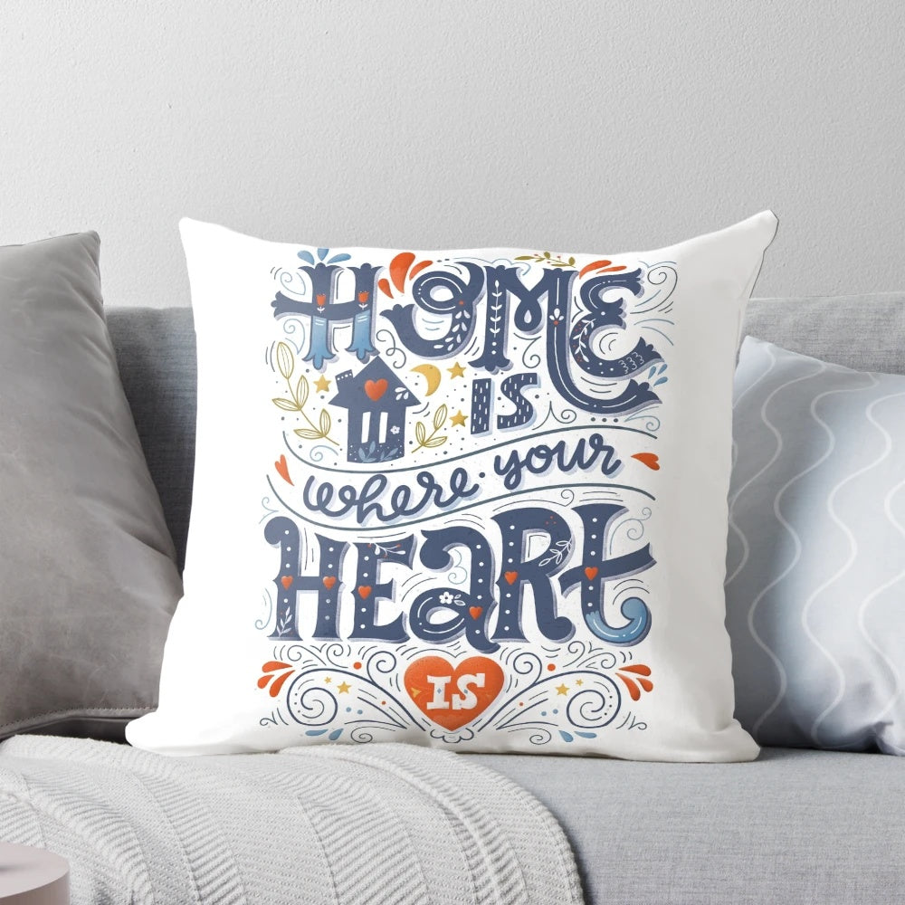 A decorative throw pillow with the inspirational quote "Home is where your heart is" in a handwritten typography design.