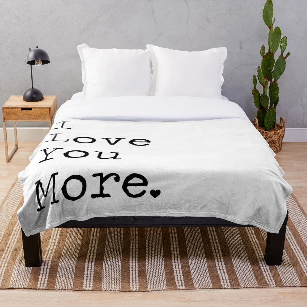 I Love You More" plush blanket with typewriter-style text
