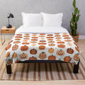 Plush blanket featuring a pattern of cute jack o' lanterns