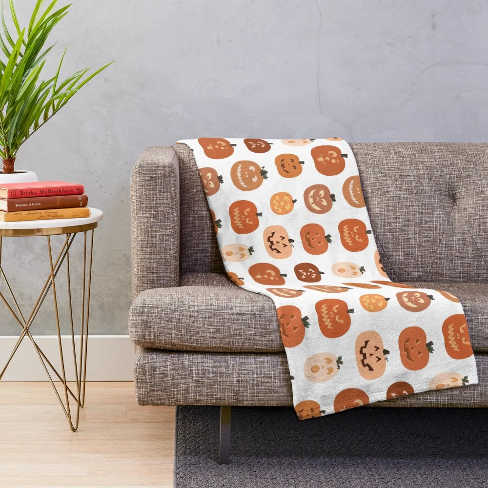 Plush blanket featuring a pattern of cute jack o' lanterns