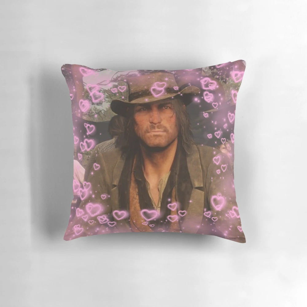 A plush, decorative pillow featuring a heart design and the character John Marston from the Red Dead Redemption video game series.