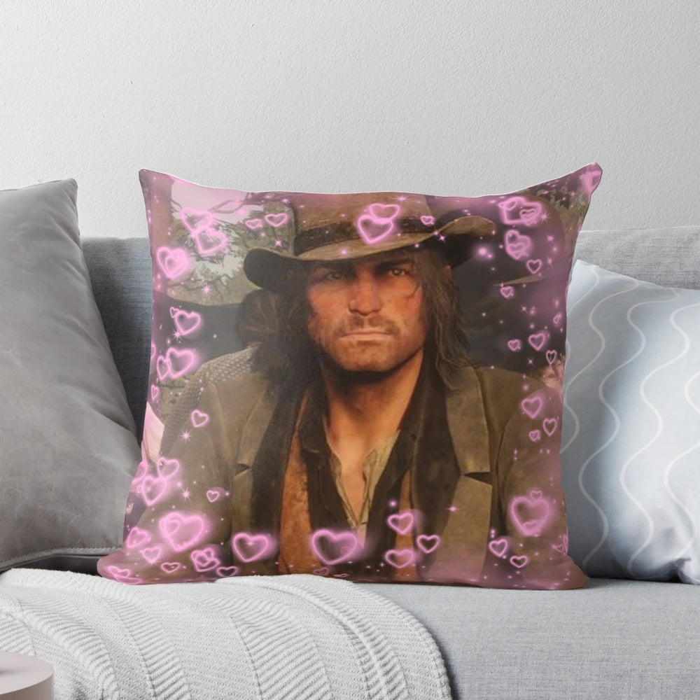 A plush, decorative pillow featuring a heart design and the character John Marston from the Red Dead Redemption video game series.