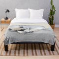 A soft, plush blanket featuring a sleeping keeshond puppy