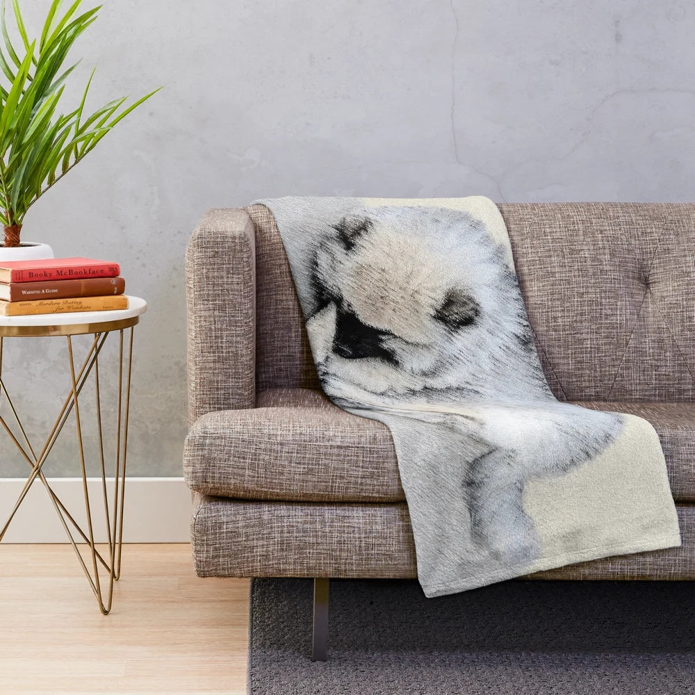 A soft, plush blanket featuring a sleeping keeshond puppy