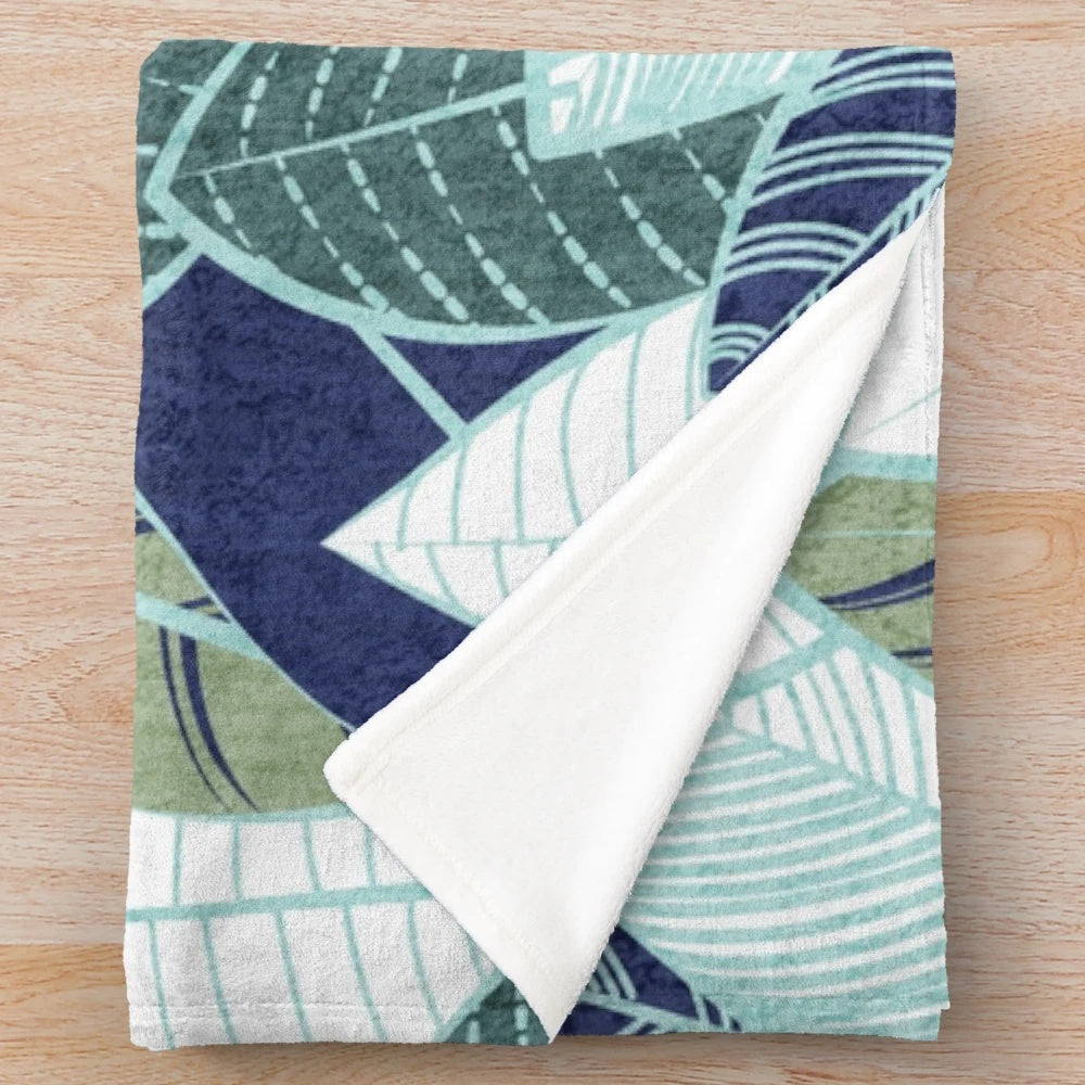 Plush blanket featuring a leaf wall design in navy blue, pine, and sage green
