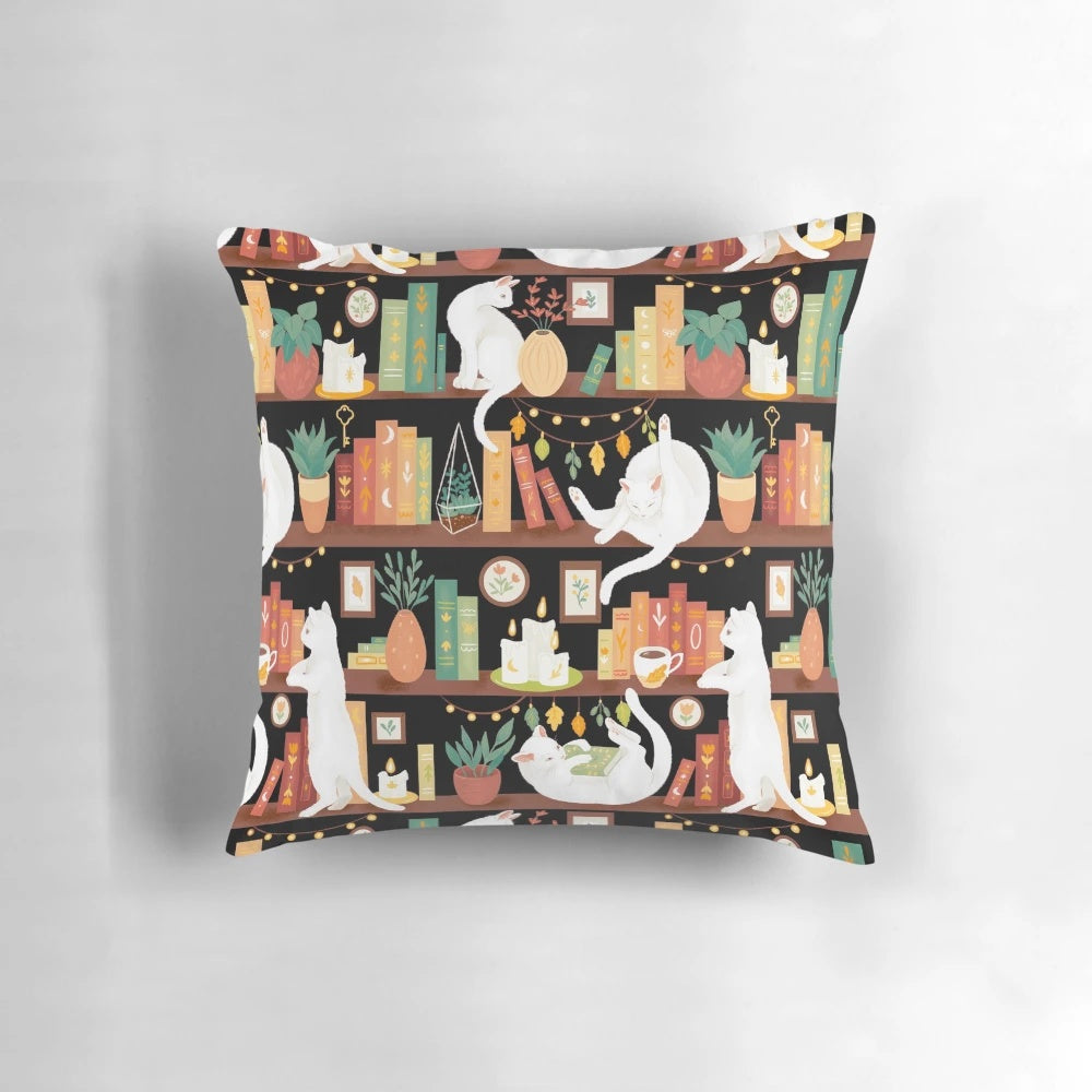 A cozy black and white cat sleeping on a bookshelf pillow with books, candles, and a cup of tea