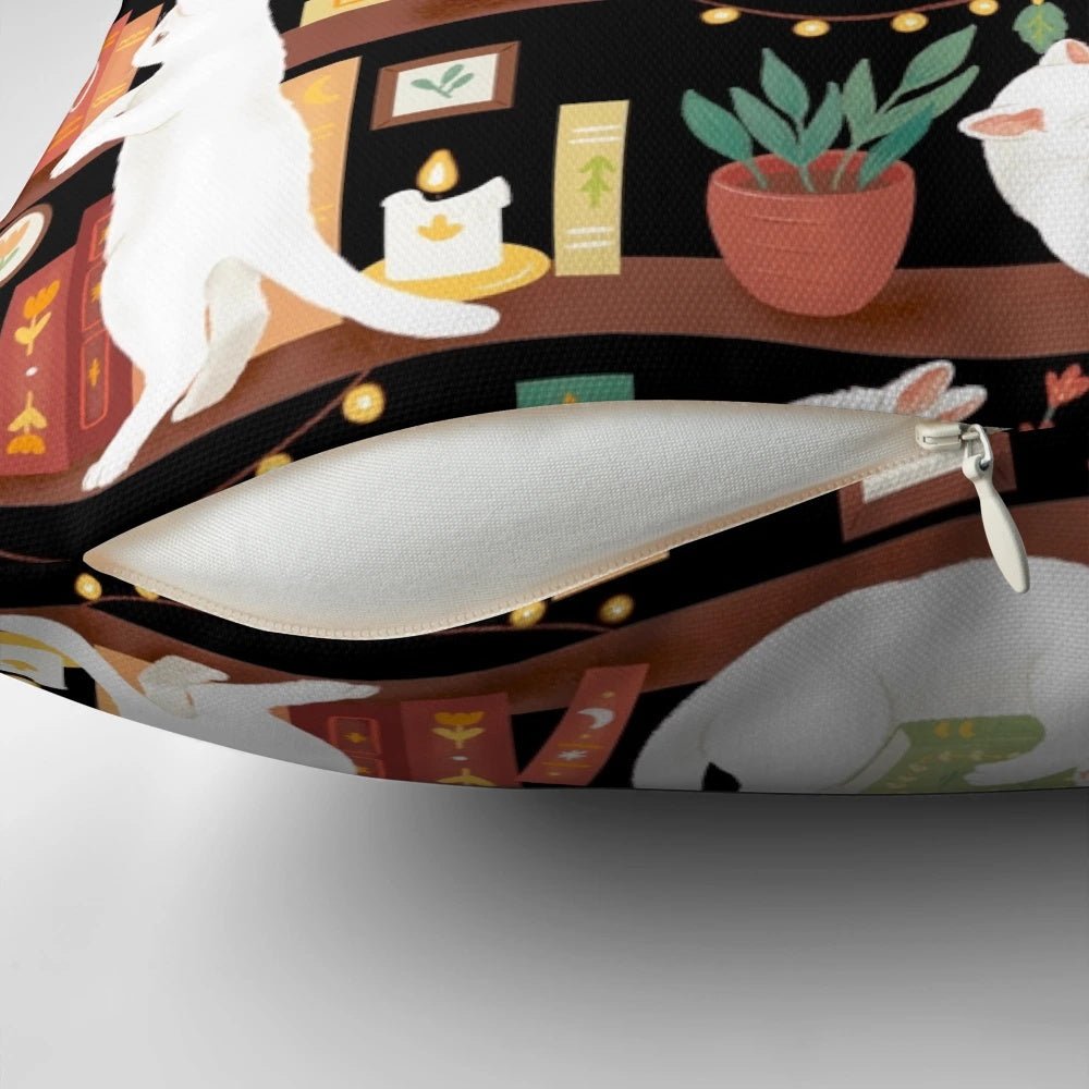 A cozy black and white cat sleeping on a bookshelf pillow with books, candles, and a cup of tea