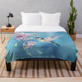 Lilac-colored plush blanket with a watercolor hummingbird design