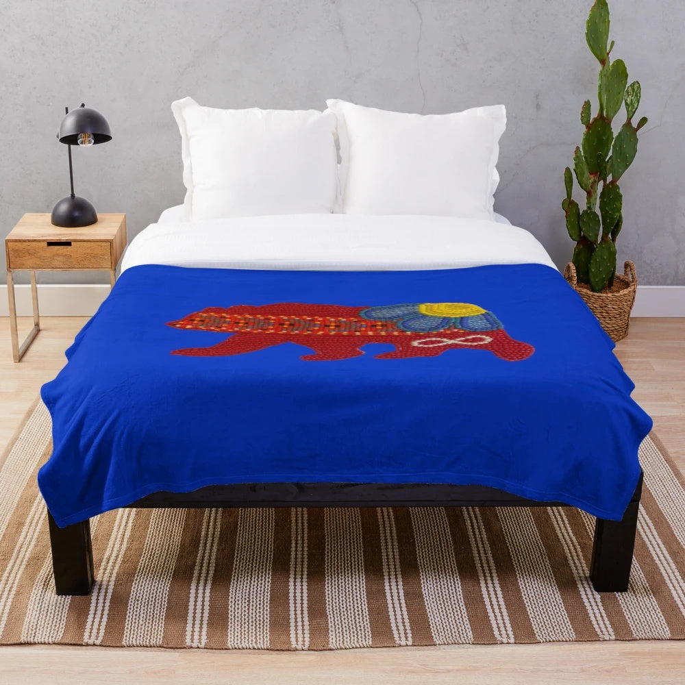 Métis bear plush blanket with floral design and beadwork sash