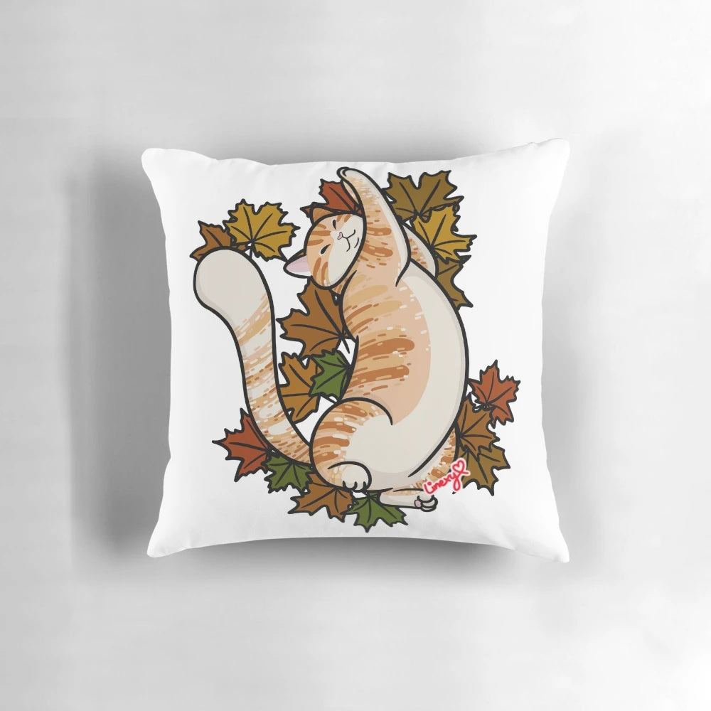 Close-up of an orange tabby cat curled up on a pillow with colorful maple leaves, perfect for fall decor.