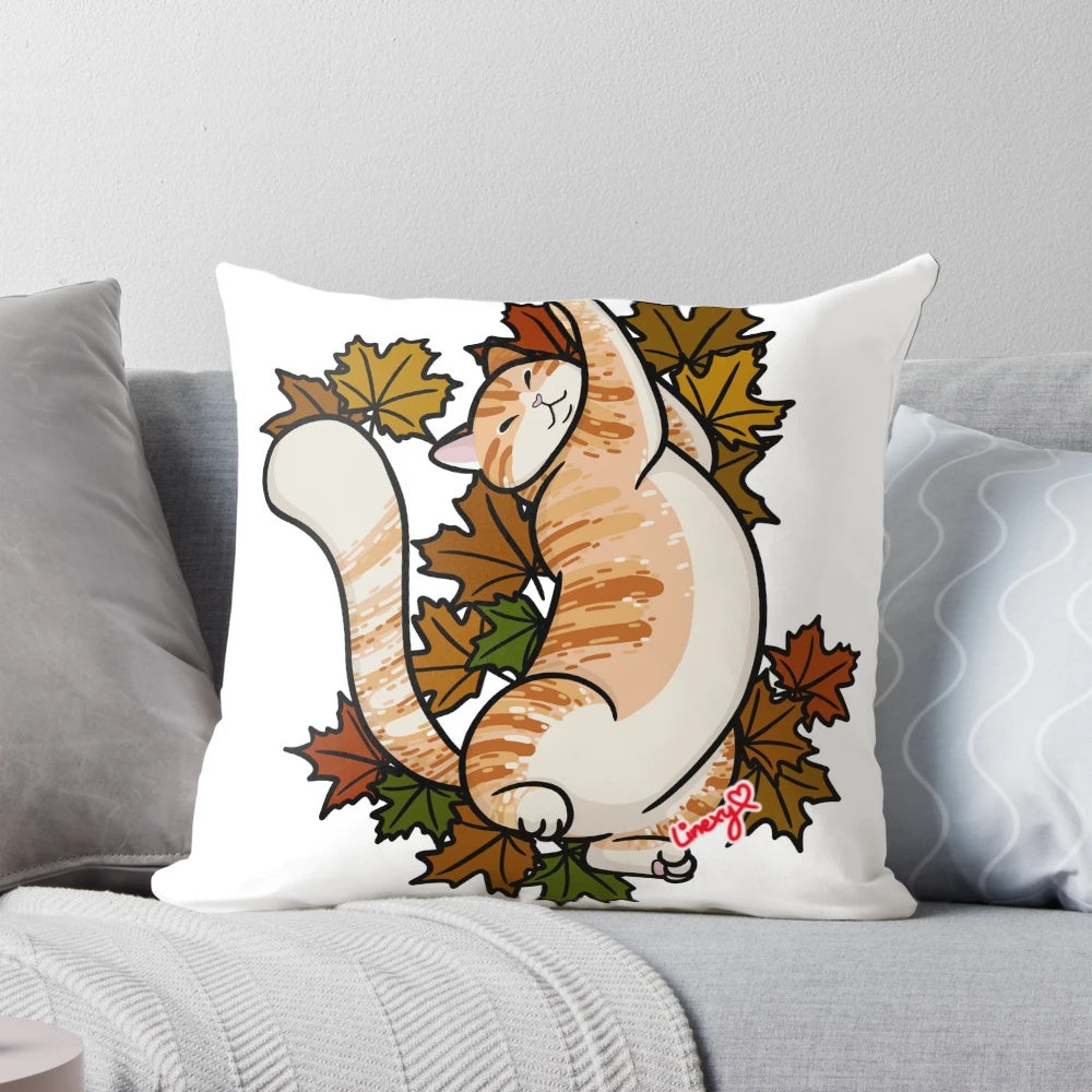 Close-up of an orange tabby cat curled up on a pillow with colorful maple leaves, perfect for fall decor.