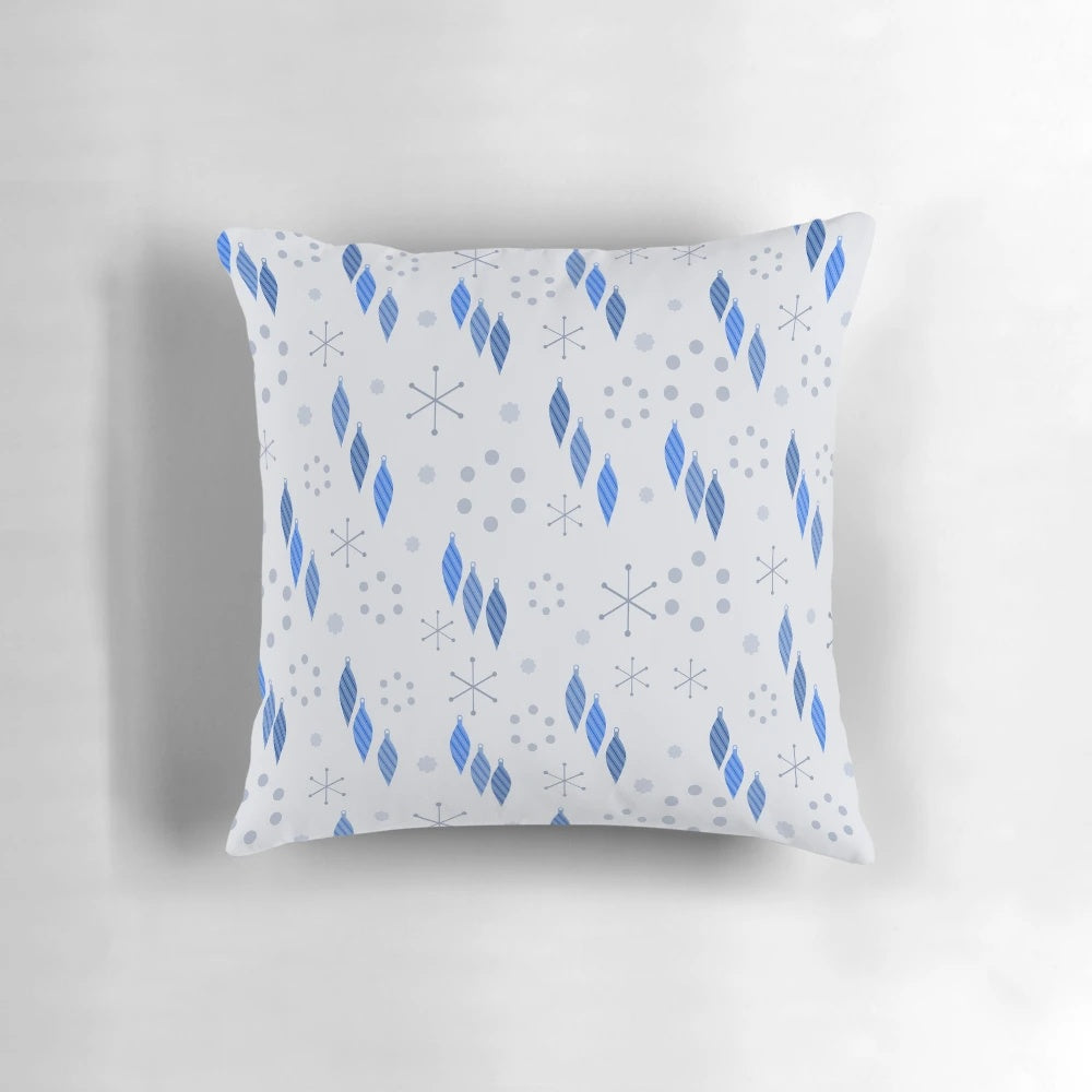 A mid century modern style pillow featuring a winter holiday design with sputnik starbursts, snowflakes, and ornaments.