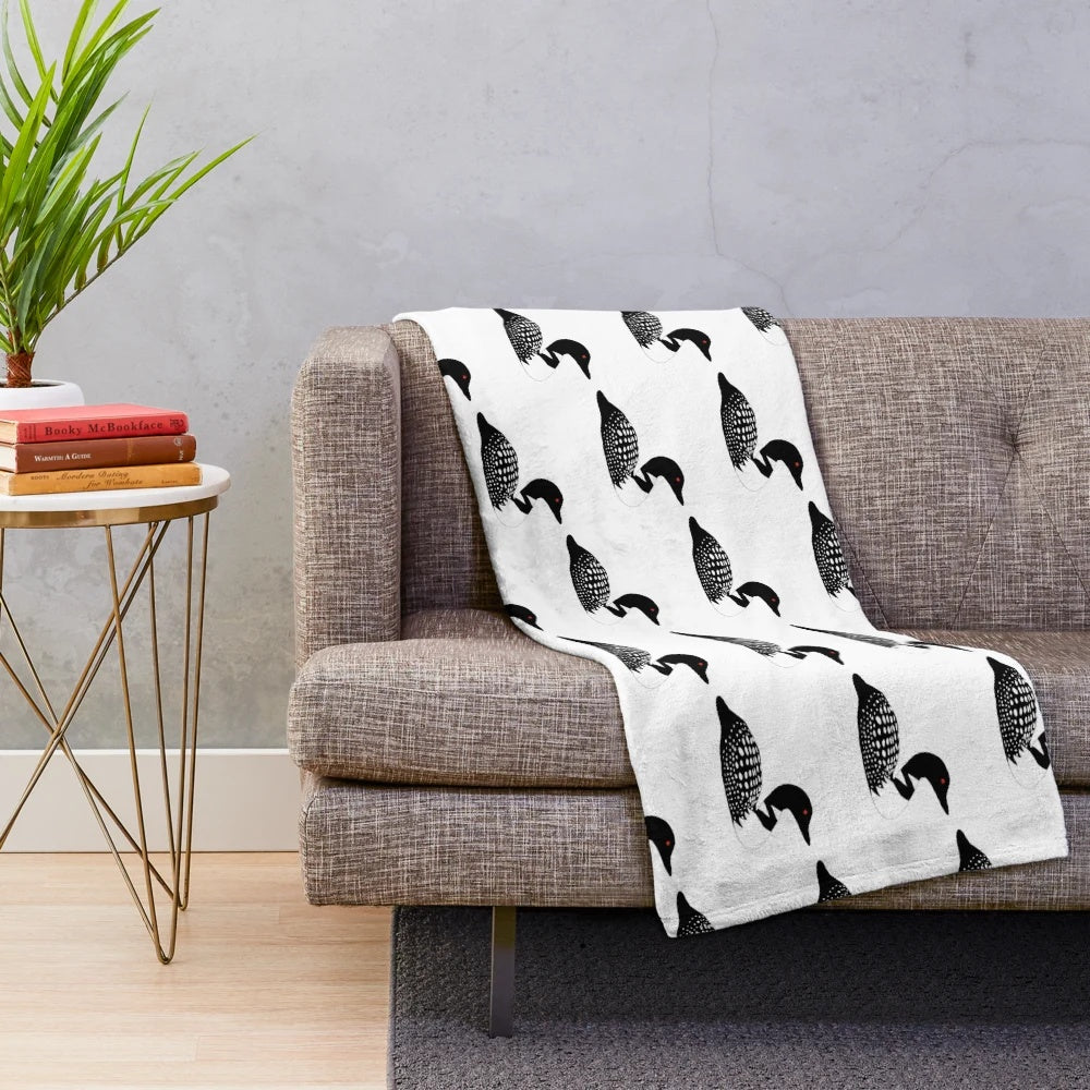Minnesota lake loon plush blanket featuring a black and white bird with a red eye sitting on a boat in a summer lake landscape