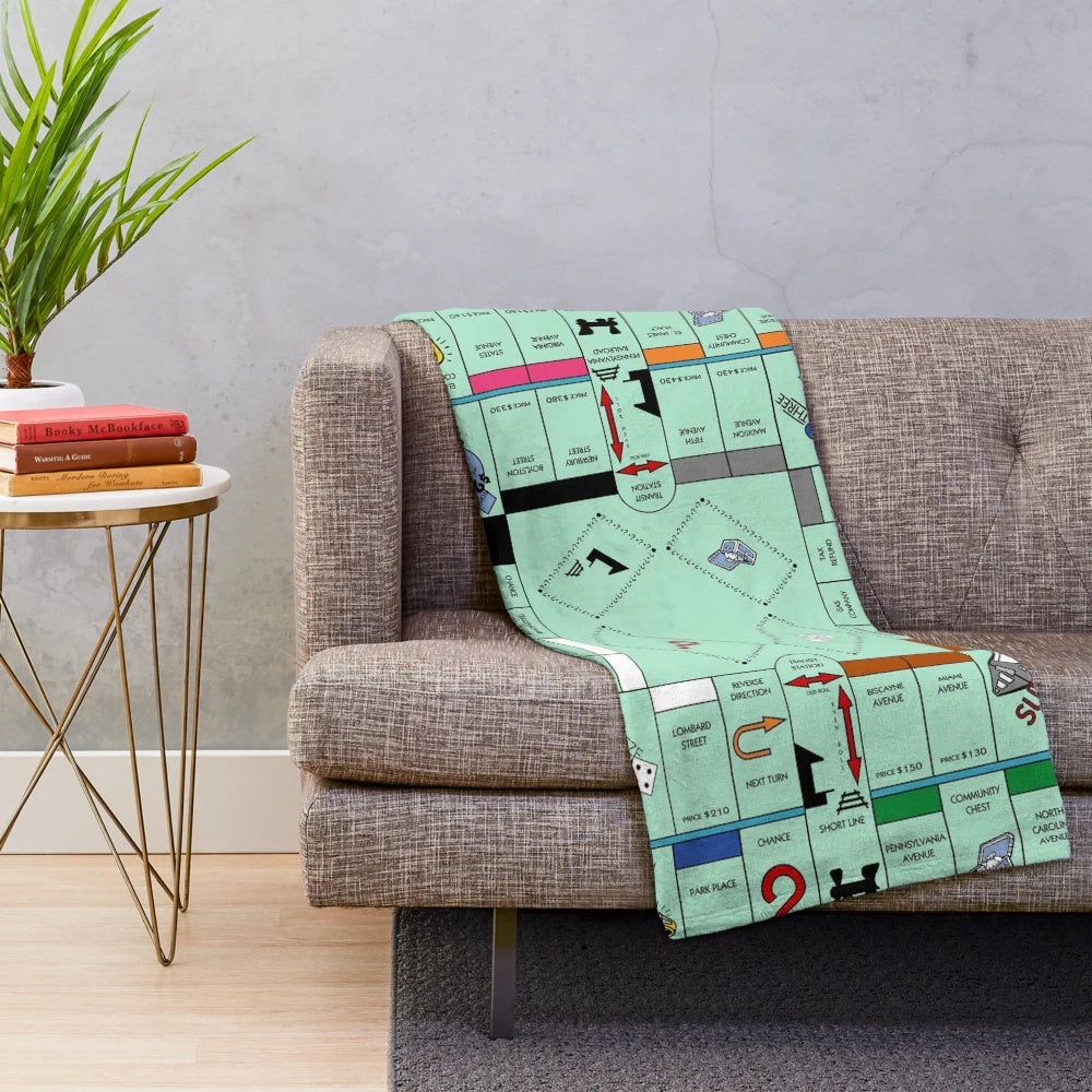 Soft and cozy plush blanket with a Monopoly-inspired board game design
