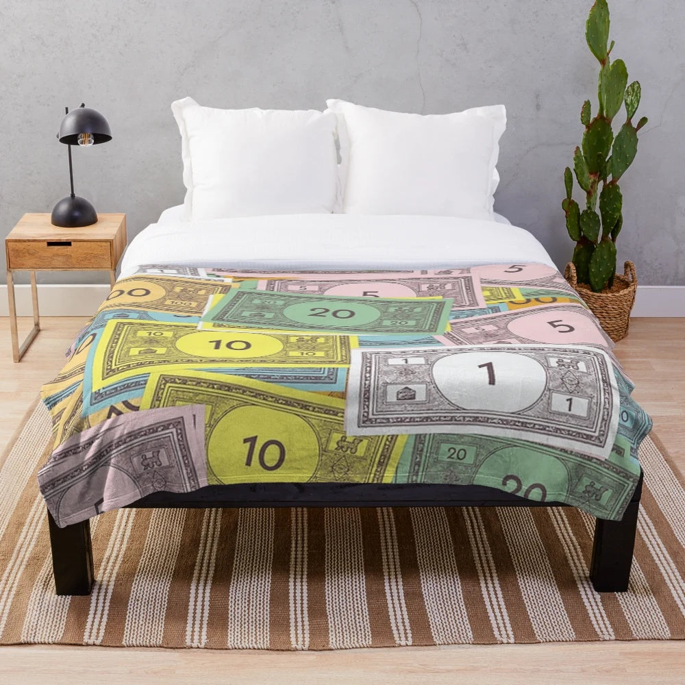Monopoly-themed plush blanket with iconic character and money design
