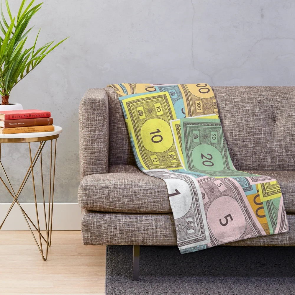 Monopoly-themed plush blanket with iconic character and money design