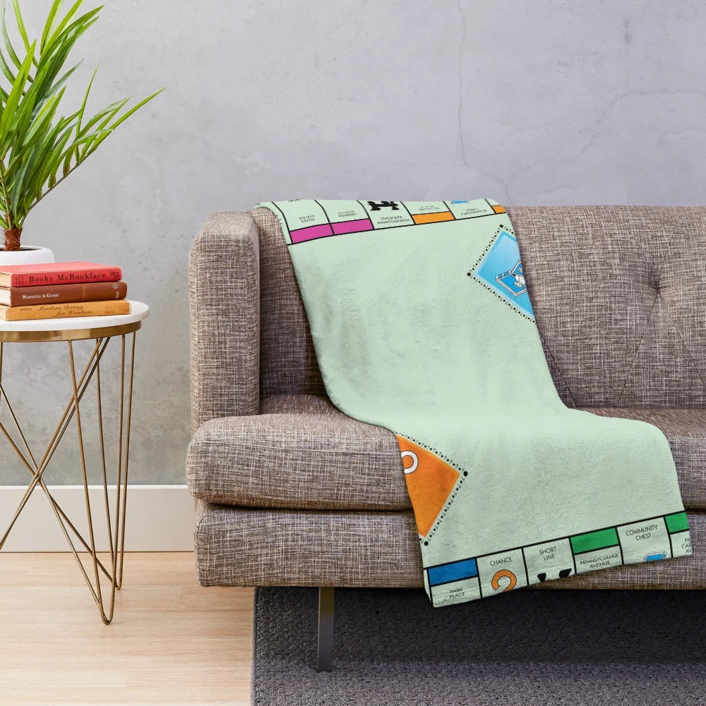Monopoly-themed plush blanket with classic board game design