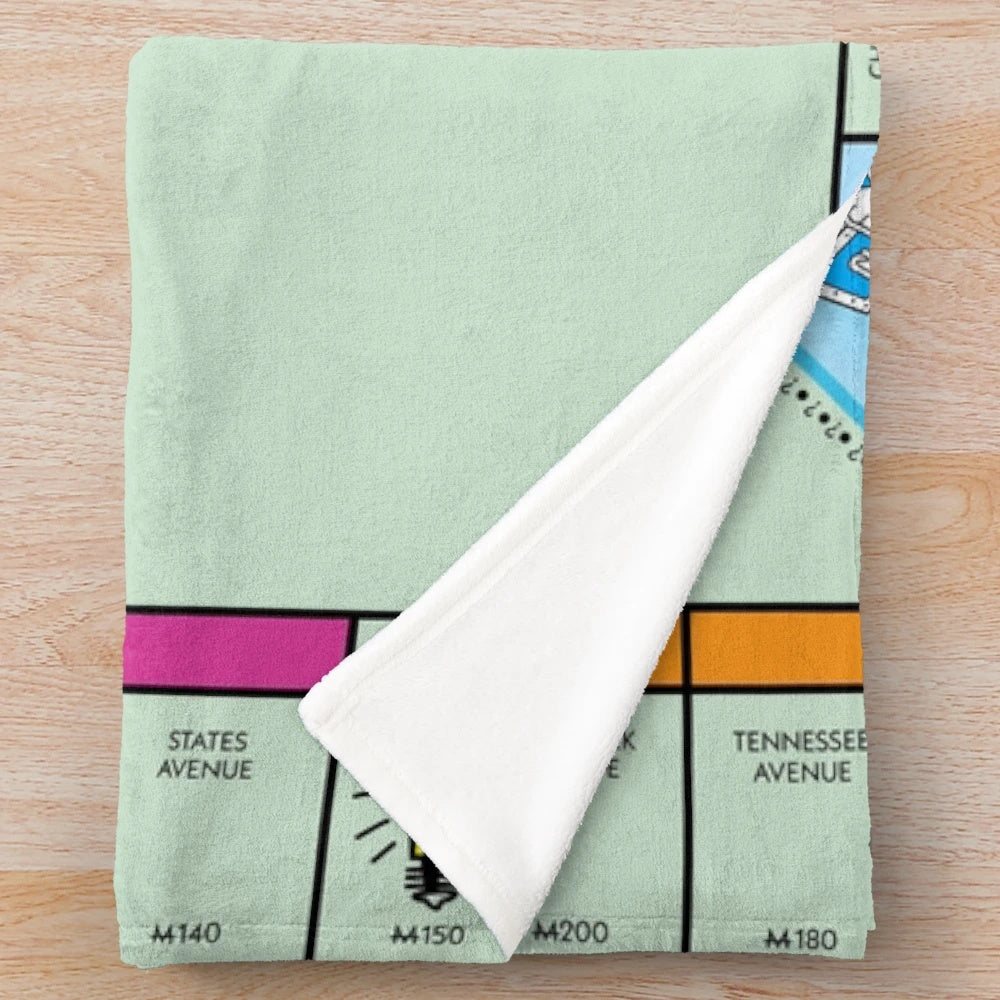 Monopoly-themed plush blanket with classic board game design