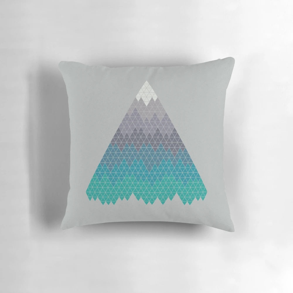 A decorative mountain-themed pillow featuring a minimalist geometric pattern in shades of blue and white.