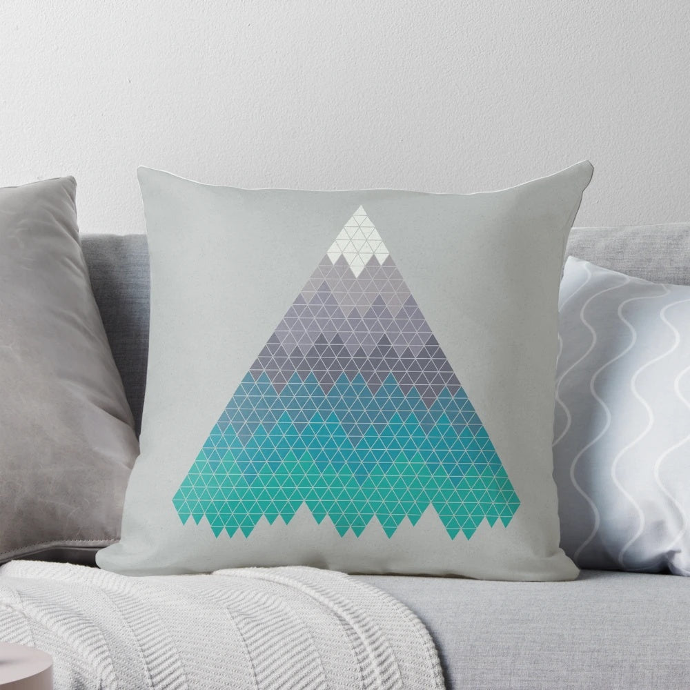 A decorative mountain-themed pillow featuring a minimalist geometric pattern in shades of blue and white.