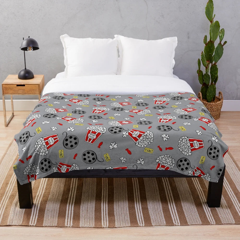 A cozy plush blanket featuring a movie night and snack themed design