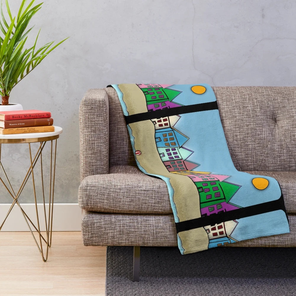 Cozy movie-themed plush blanket featuring digital artwork of houses, sun, beach, and cinema