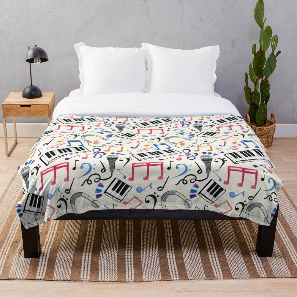 A plush, patterned blanket featuring musical notes and symbols in various colors.