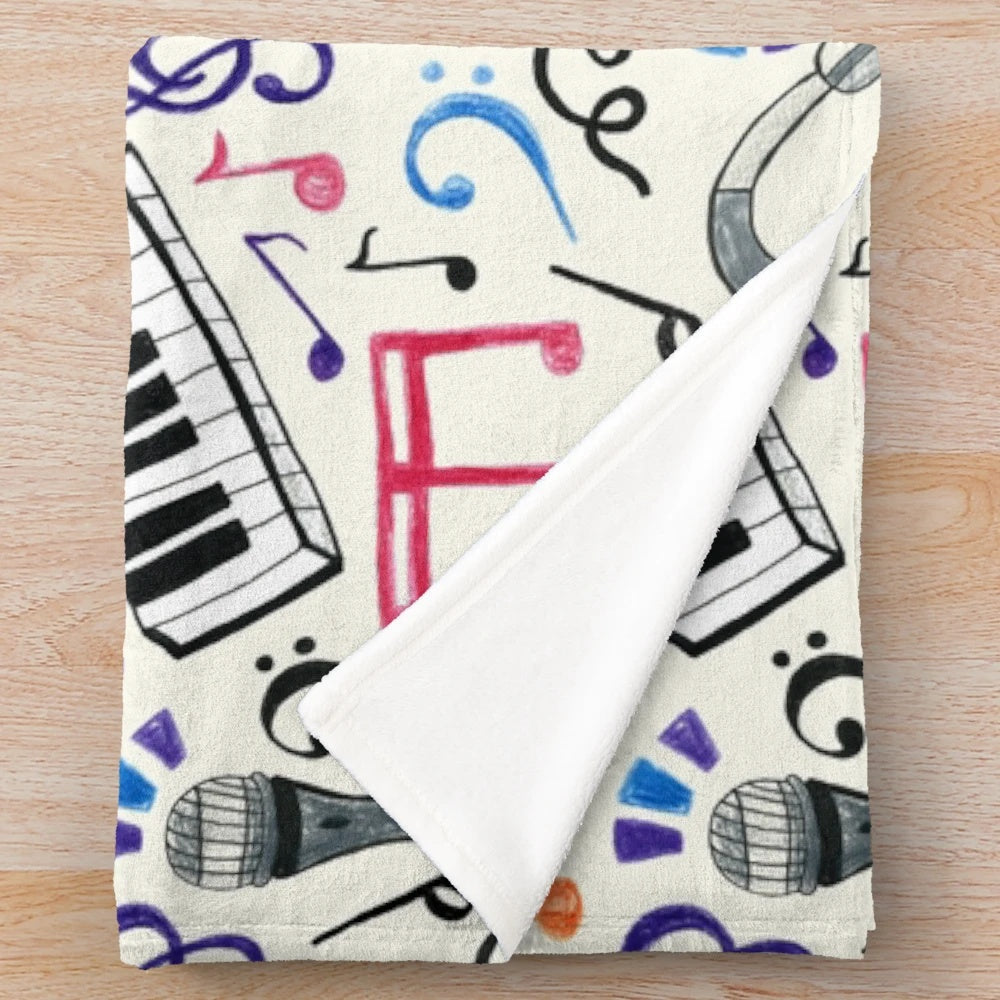 A plush, patterned blanket featuring musical notes and symbols in various colors.