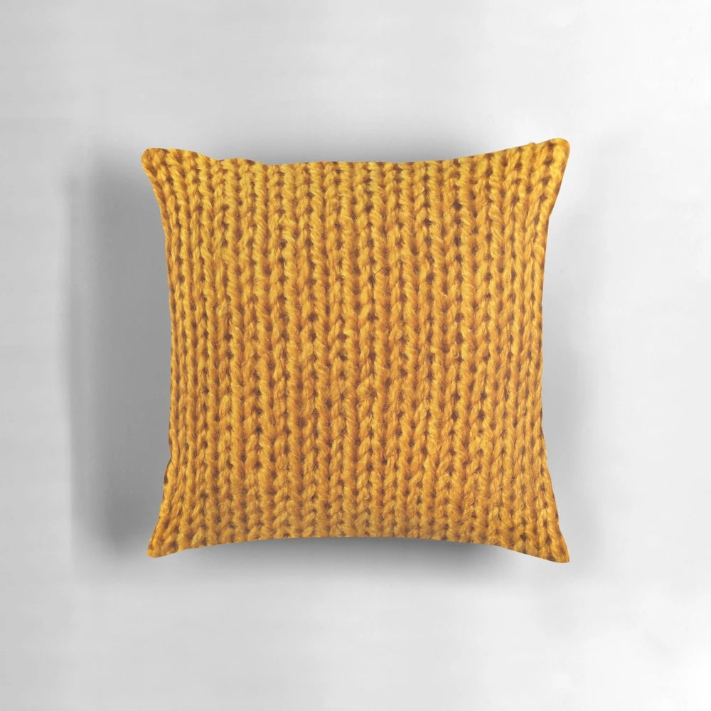Closeup of a soft, fuzzy mustard yellow knit pillow for a cozy fall home.
