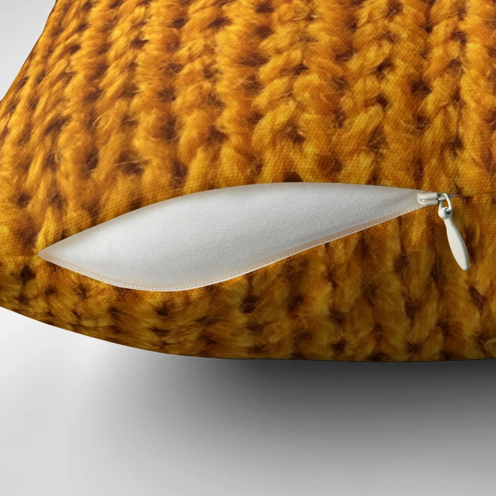 Closeup of a soft, fuzzy mustard yellow knit pillow for a cozy fall home.