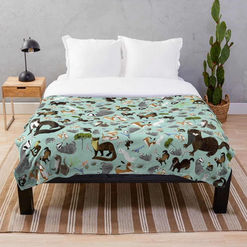 Plush blanket featuring a whimsical pattern of mustelid species like badgers, otters, and martens