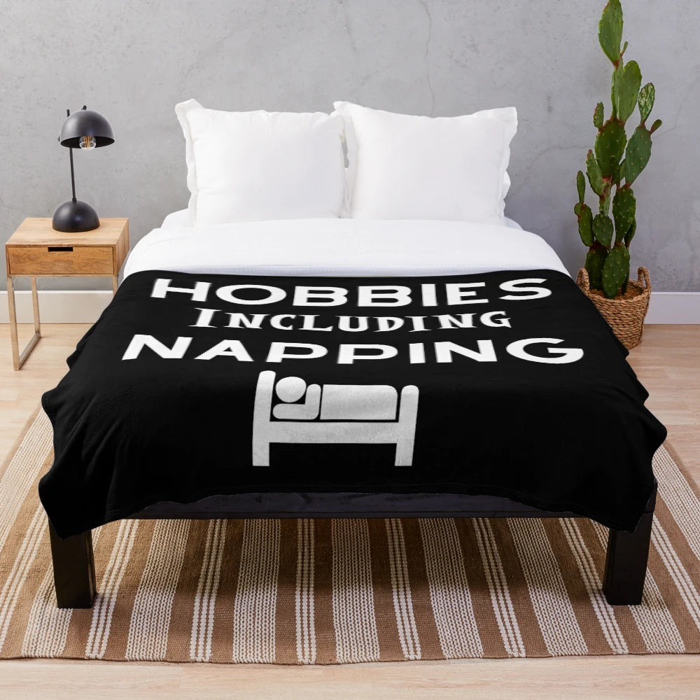 Plush blanket with "Hobbies Include Napping" design