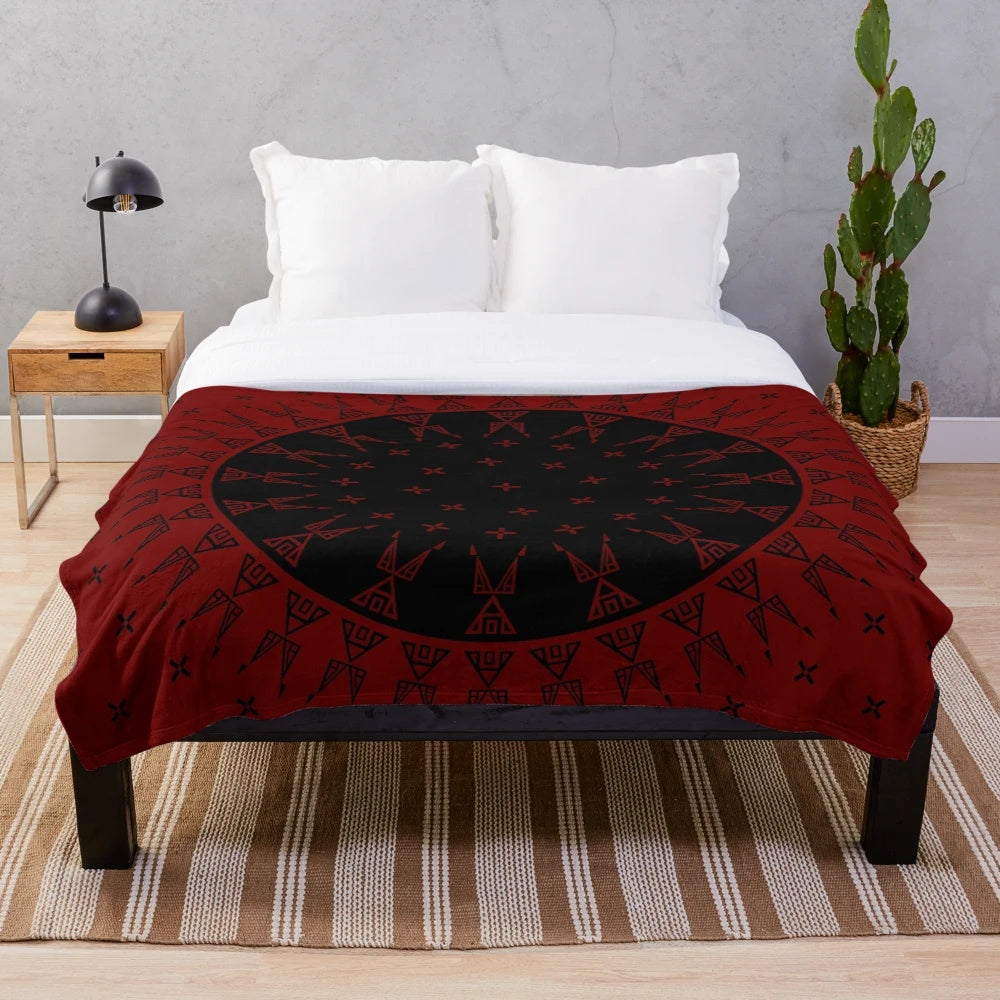 Maroon and black plush blanket with native-inspired wildlife and star designs