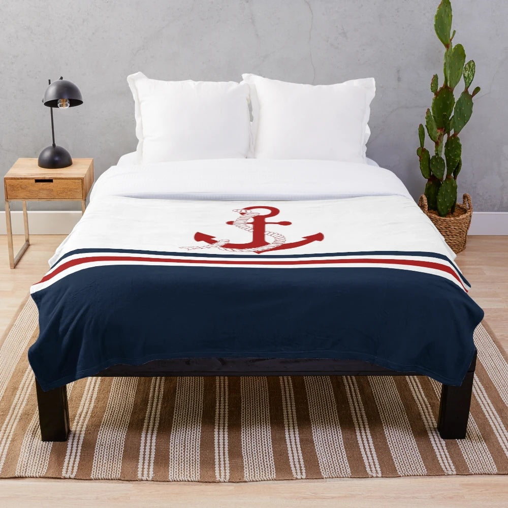 Nautical-inspired plush blanket with navy blue, white, and red striped pattern and anchor design
