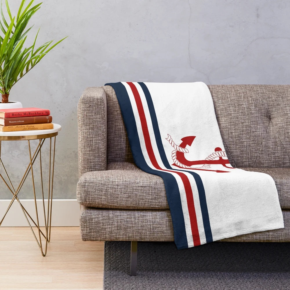 Nautical-inspired plush blanket with navy blue, white, and red striped pattern and anchor design