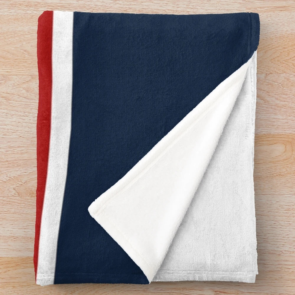 Nautical-inspired plush blanket with navy blue, white, and red striped pattern and anchor design
