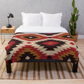 Navajo-inspired plush blanket with red and mustard colors and tribal pattern