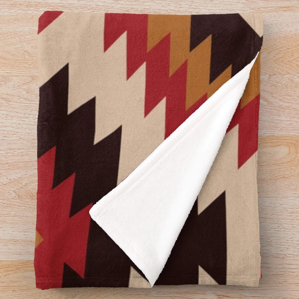 Navajo-inspired plush blanket with red and mustard colors and tribal pattern