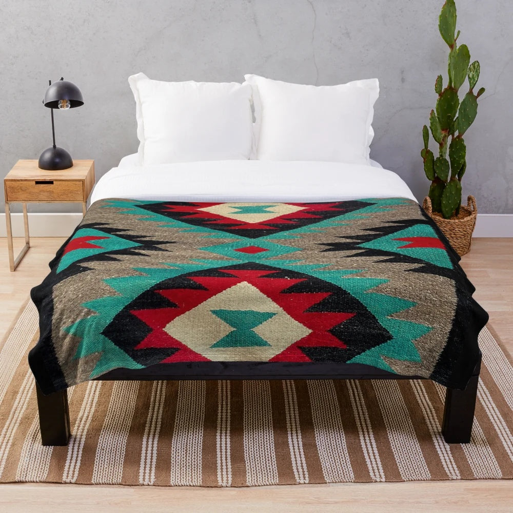 Navajo patterned plush blanket in turquoise, red, grey, and black