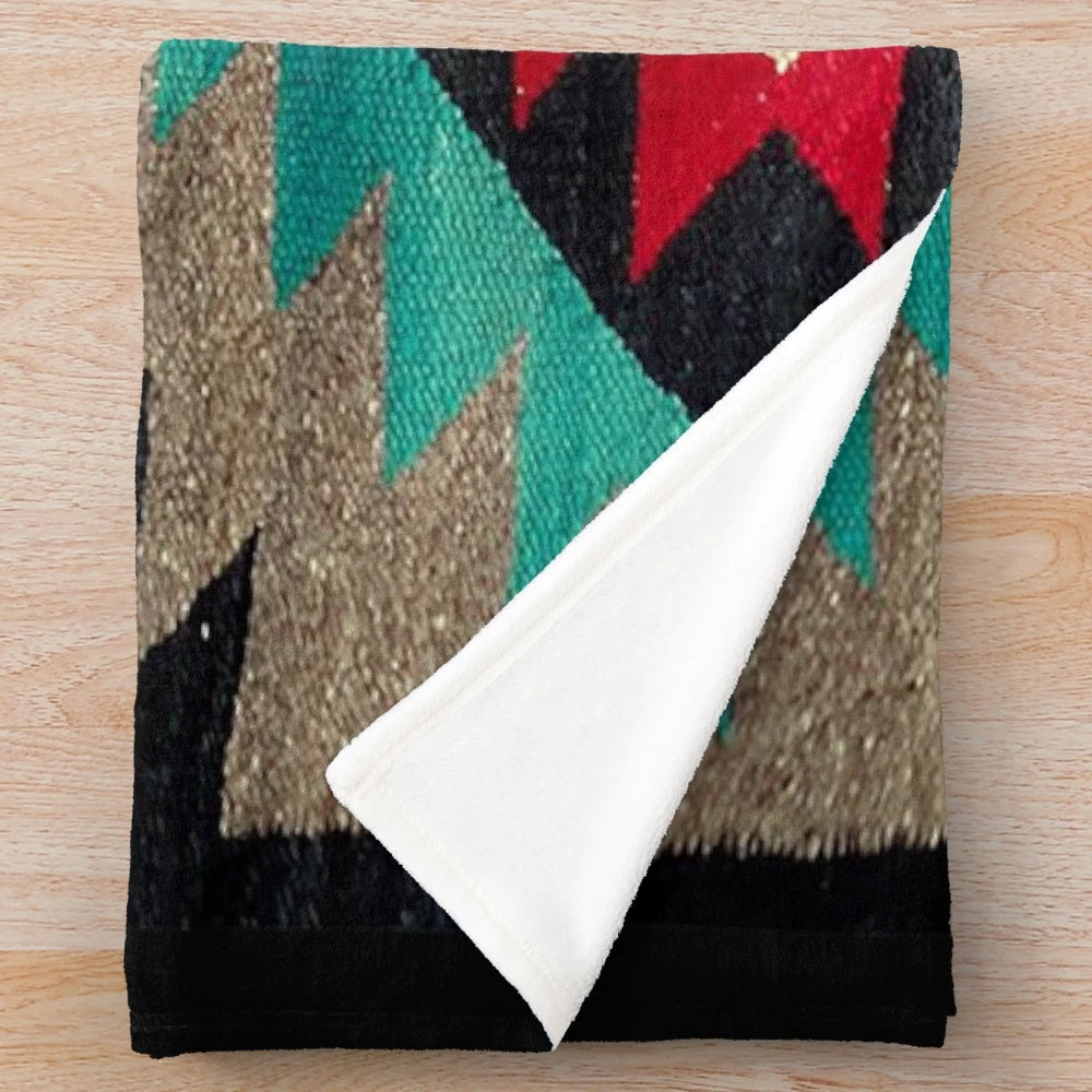 Navajo patterned plush blanket in turquoise, red, grey, and black