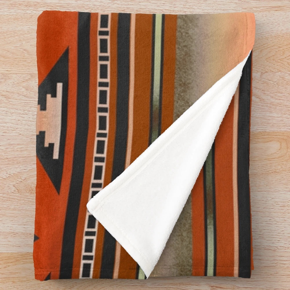Rust and teal plush blanket with Navajo-inspired geometric pattern