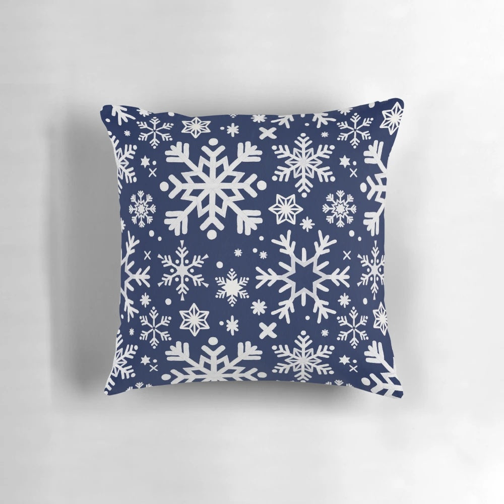 A navy blue pillow with a snowflake pattern, perfect for winter and holiday home decor.