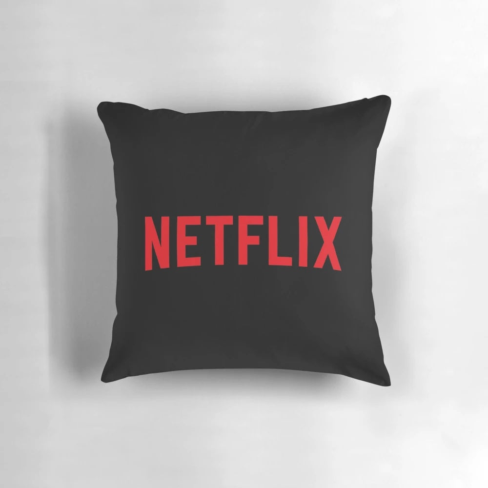 A soft, plush pillow featuring the Netflix logo in black and red colors.