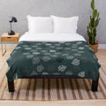 Nook Leaf plush blanket with black and white logo on green background