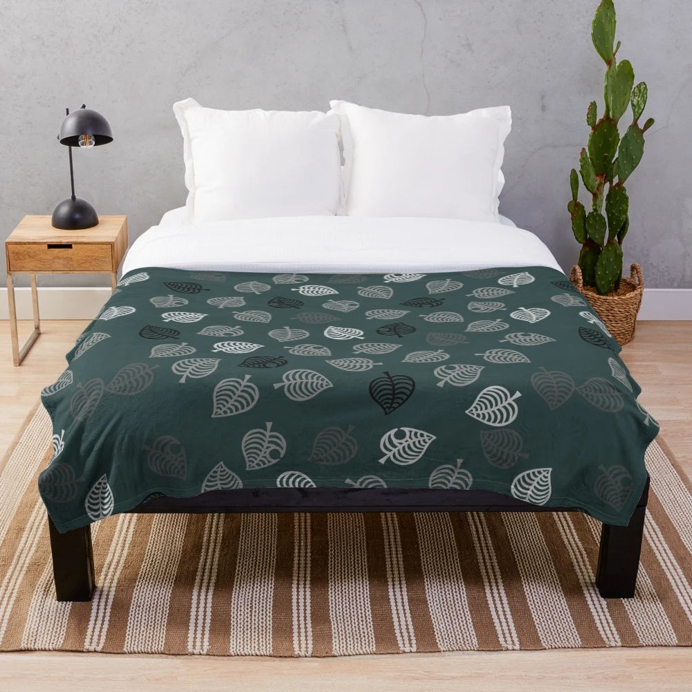 Nook Leaf plush blanket with black and white logo on green background