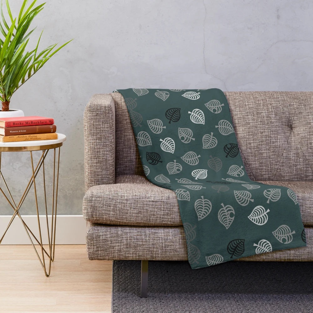 Nook Leaf plush blanket with black and white logo on green background