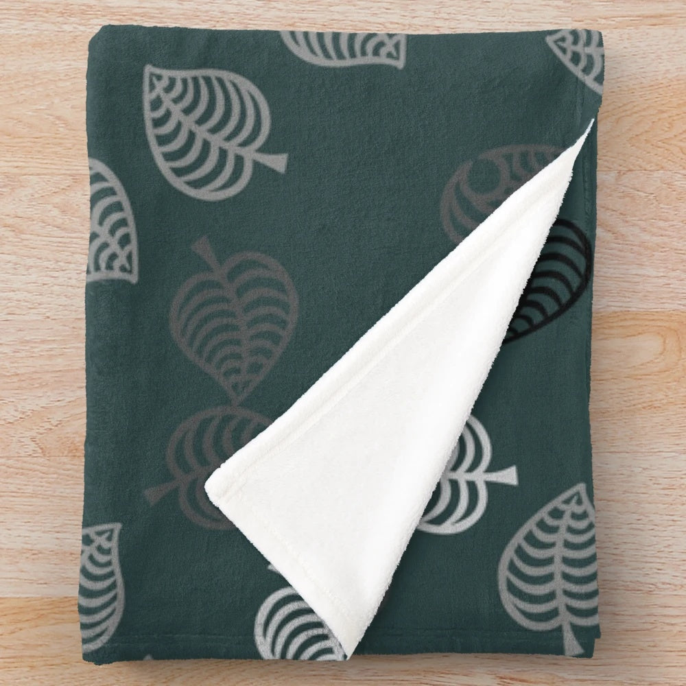 Nook Leaf plush blanket with black and white logo on green background