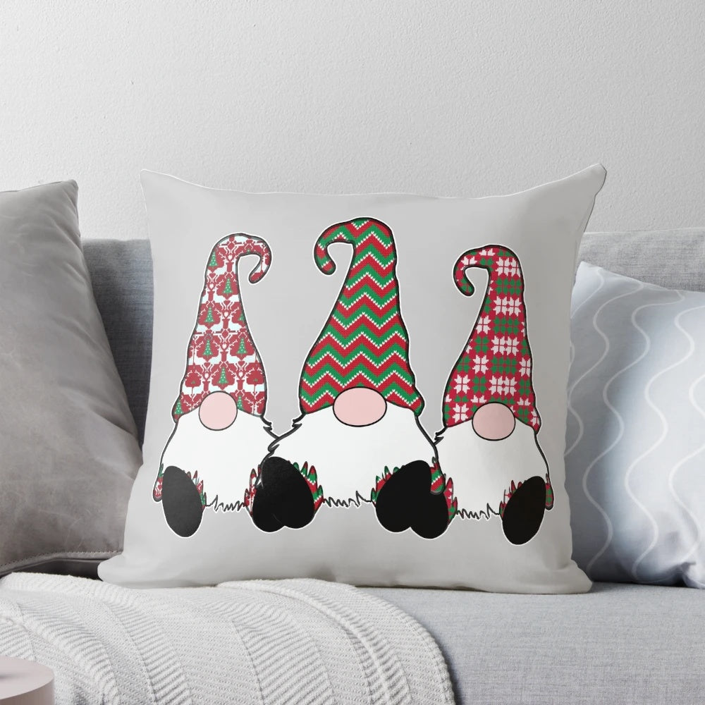 A festive throw pillow featuring adorable Nordic gnomes or tomte elves in traditional Scandinavian red hats.